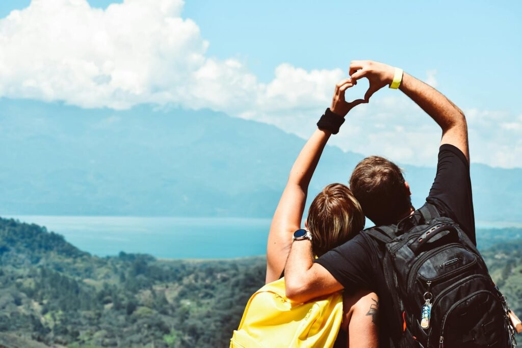 Couple making a heart shape with arms over a beautiful view in Honduras.